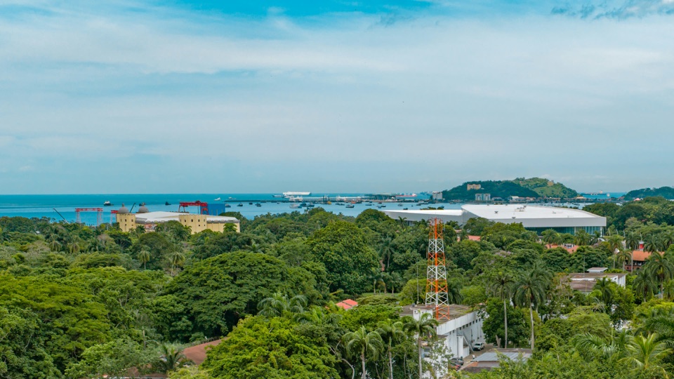 La Calzada de Amador con el techo blanco del centro de convenciones, la marina y los cerros de las islas sobre las copas de los árboles
